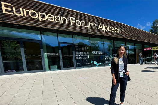 Amelie steht vor dem Eingangsbereich zum Europäischen Forum Alpbach