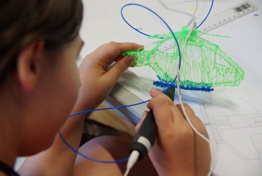 A child ‘draws’ a helicopter using a 3D doodler.