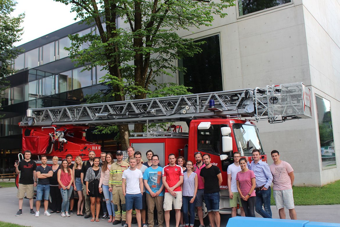 Die Studierenden der Facility Management Studiengänge der FH Kufstein Tirol mit einer Drehleiter der Freiwilligen Feuerwehr Kufstein und dem ALF (ganz links im Bild)