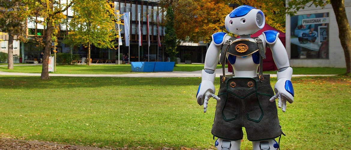 Roboter NAO in Lederhose am Campus der Fachhochschule Kufstein Tirol.