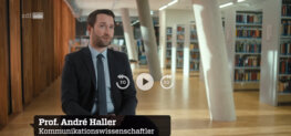 FH-Professor Haller während des Interviews im ZDF-Info-Programm, sitzend vor dem Hintergrund der FH-Bibliothek